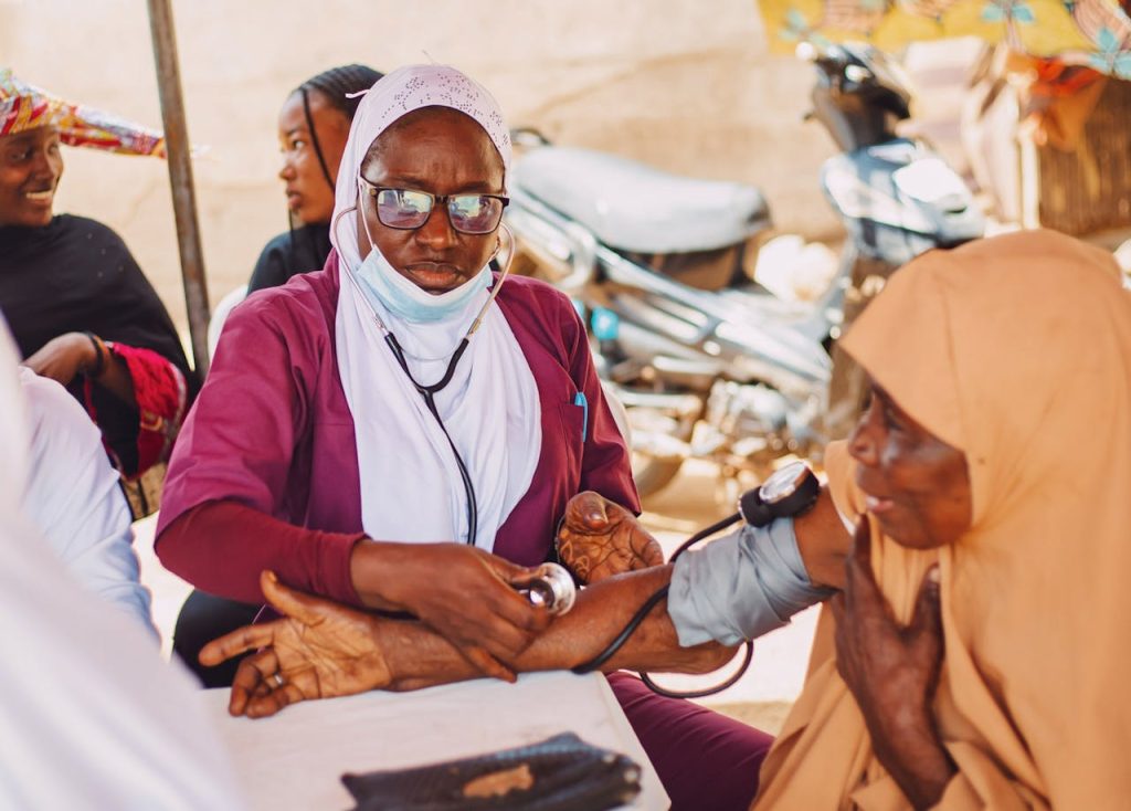 pexels photo 33132346 Outdoor portrait of healthcare professional attending to a patient, promoting community wellness in Kaduna, Nigeria.